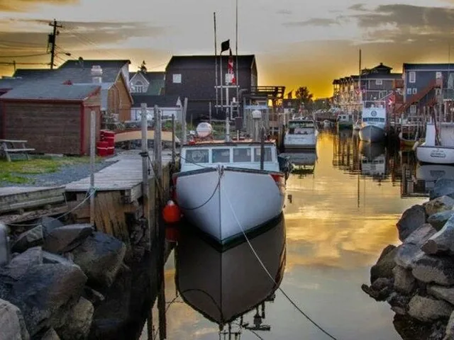 Boote in einer ruhigen Hafenbucht bei Sonnenuntergang, die sich im Wasser spiegeln