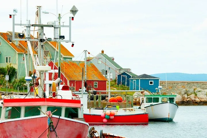 Fishing boats docked in a colorful coastal village with red and blue buildings.